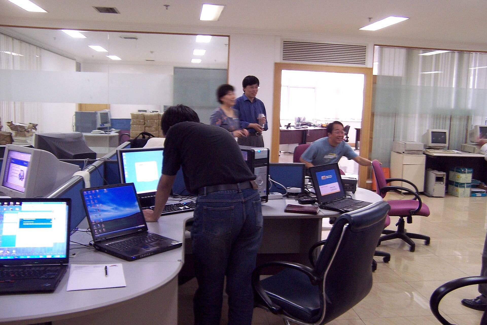 Office interior with employees working at computers in a software company workspace