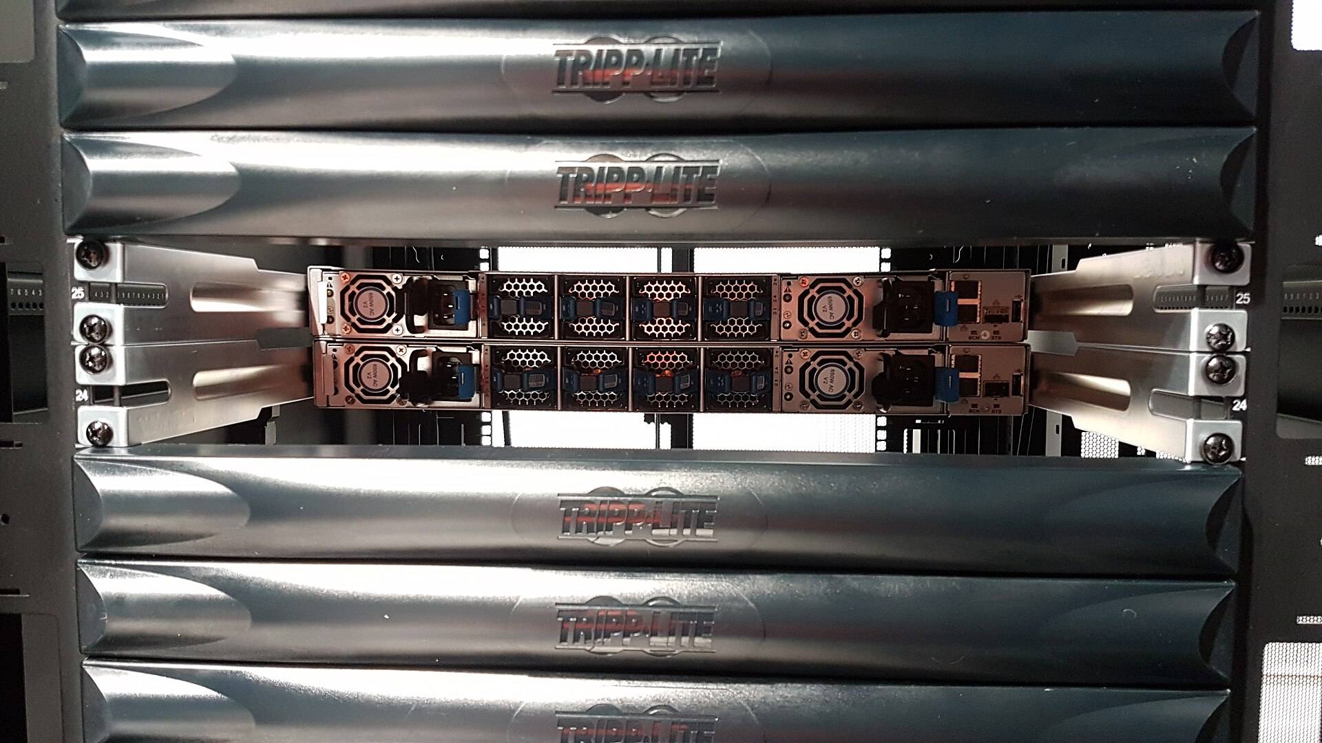 Server racks with network cabling in a summit computer room installation